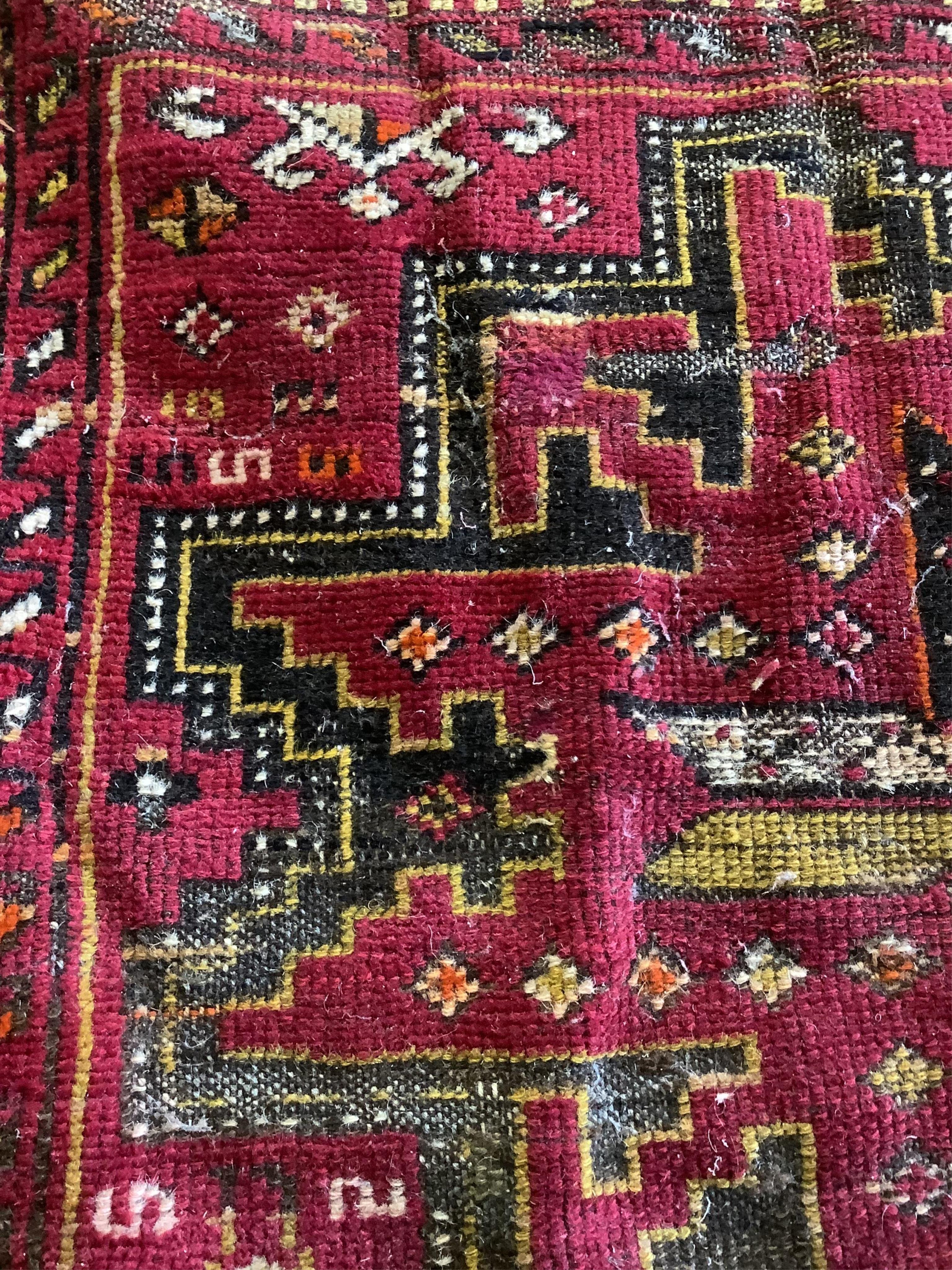 A Caucasian red ground rug, 250 x 130cm. Condition - fair